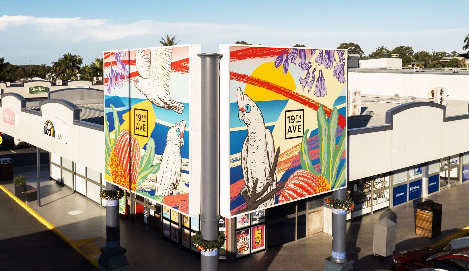 Two large-scale printed illustration panels sit over the shopping centre entrance, featuring native flora and local birds