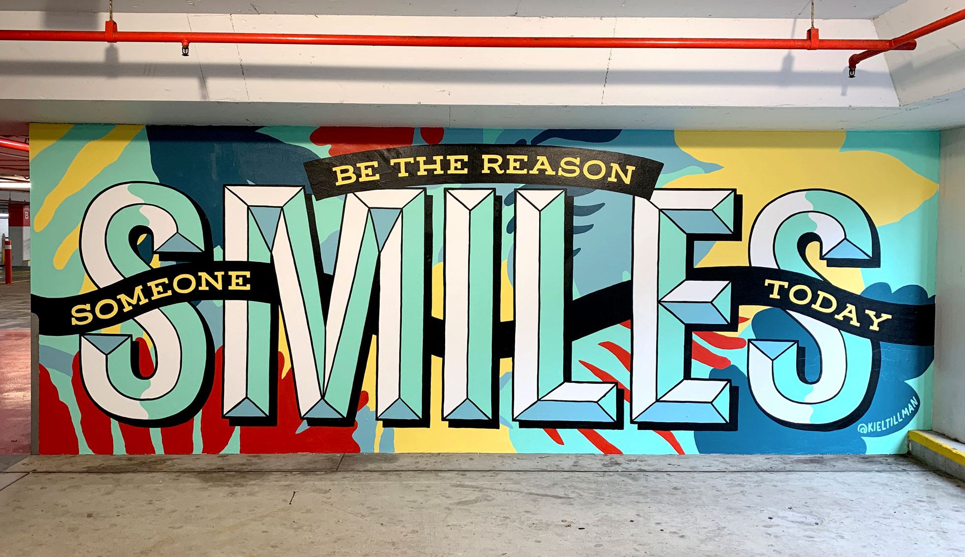 A finished shot of a colourful mural that reads 'Be the Reason to Smile'