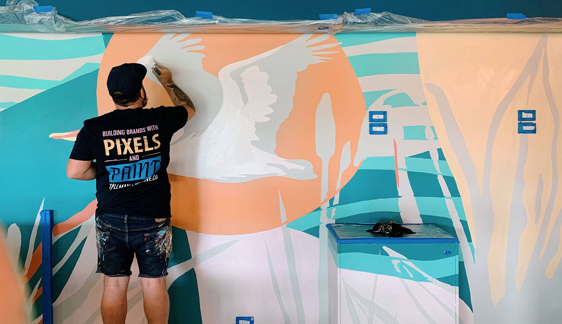 Mural artist painting an indoor custom mural at Bundall's Gold Coast Tavern