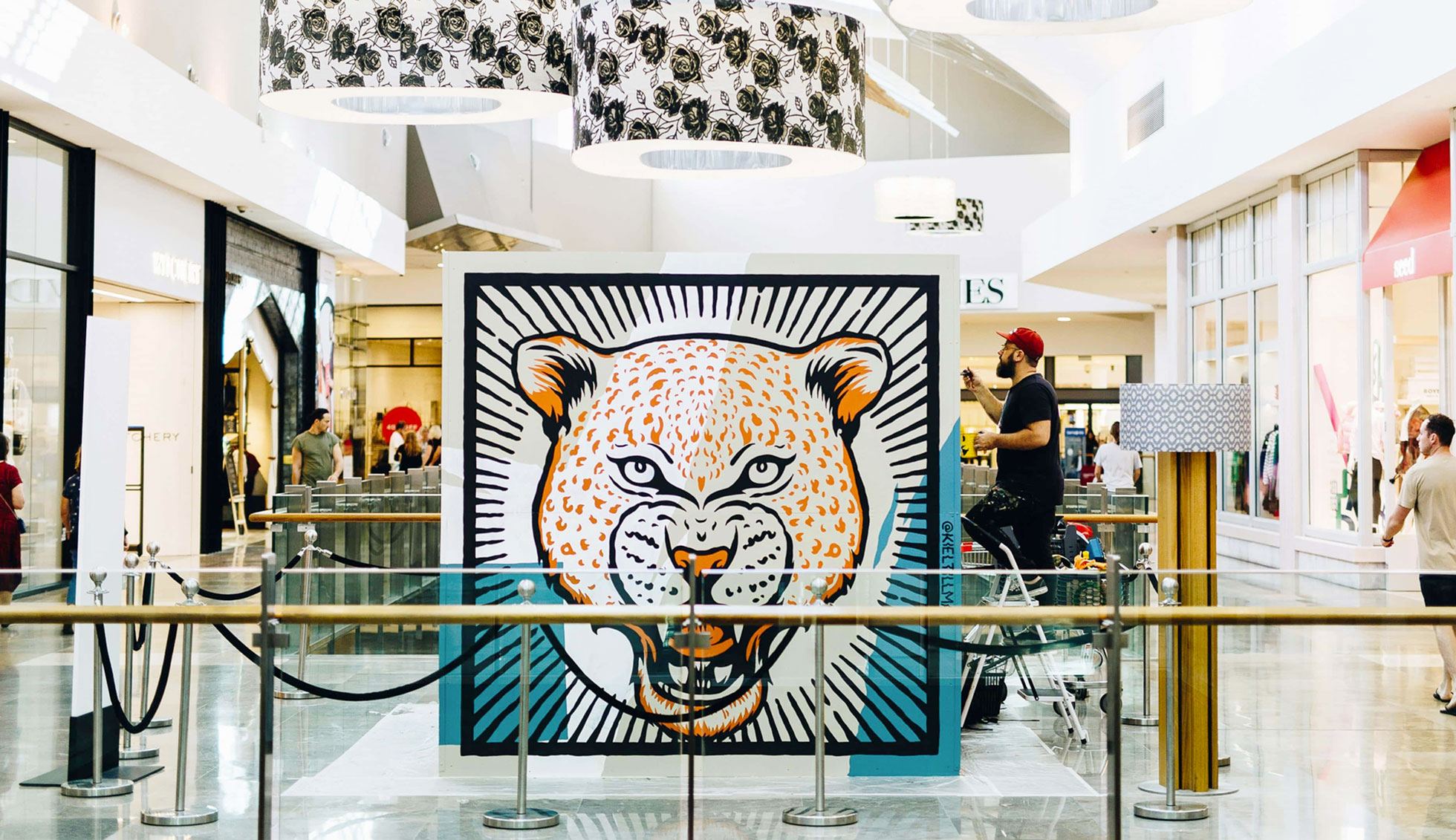 Kiel paints his 4-sided cube mural in the centre of the shopping causeway