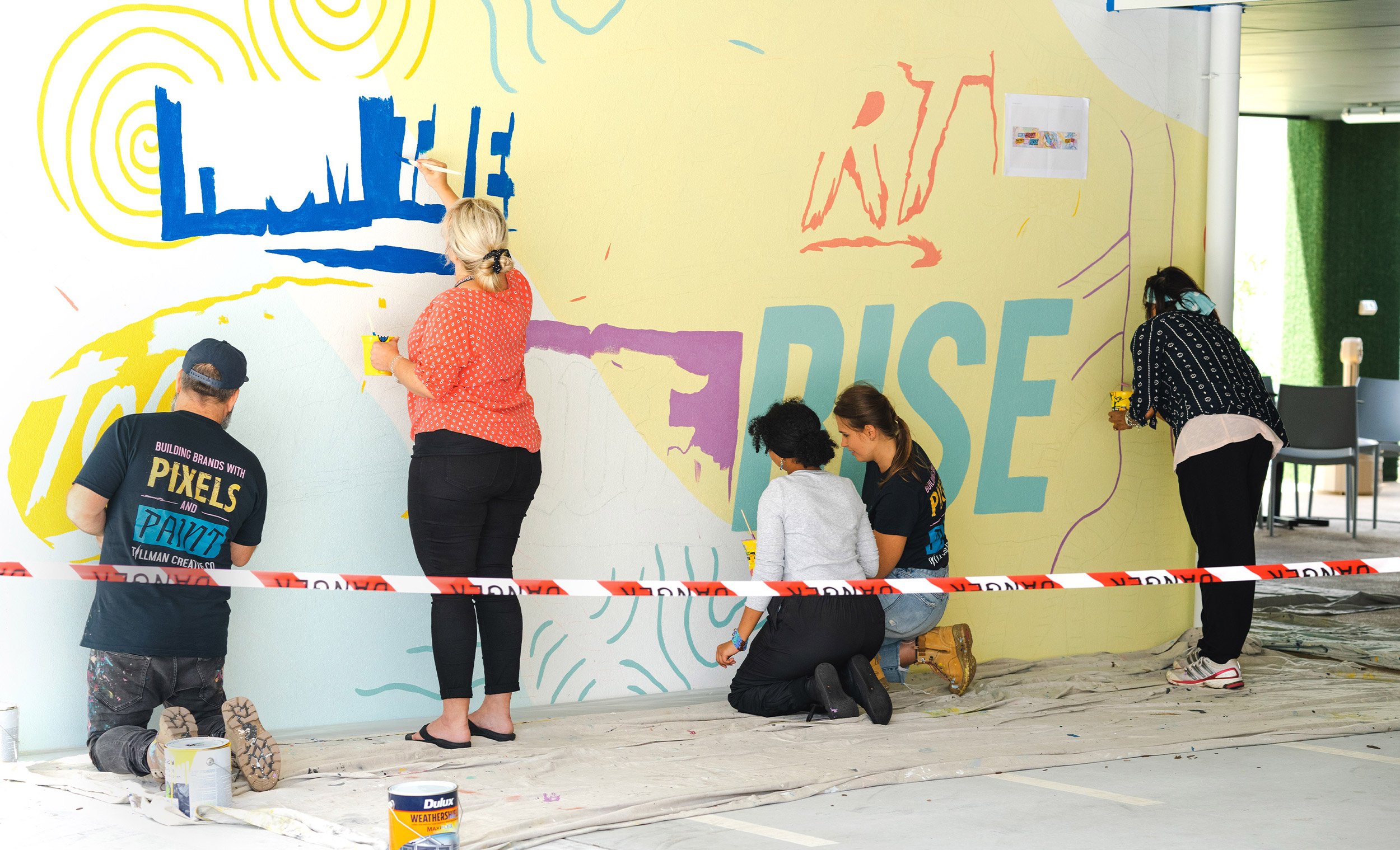 Artists, residents and support team all paint the mural together