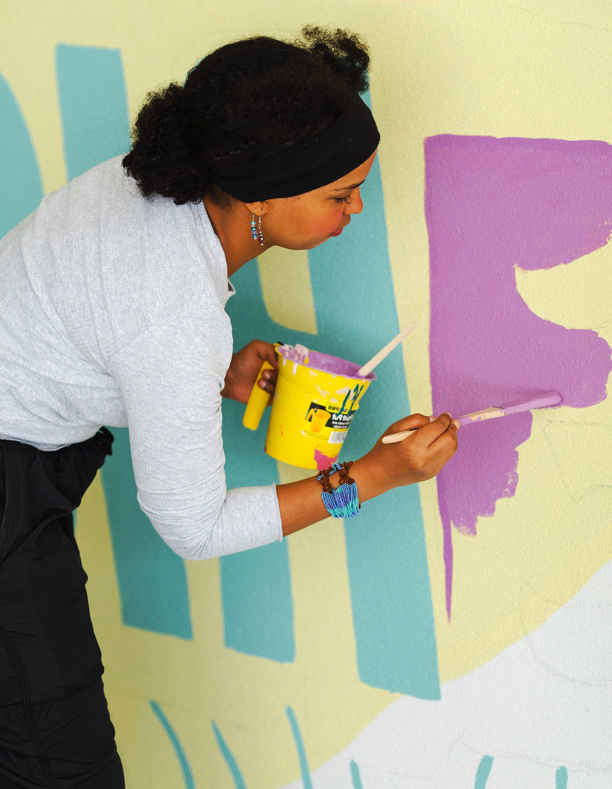 One of the Foyer residents paints the mural